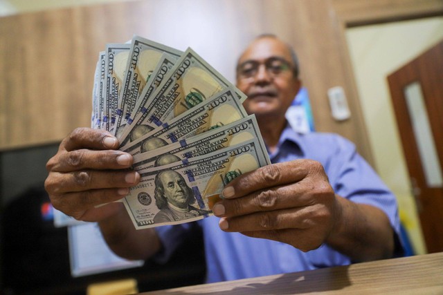 Petugas menujukkan pecahan mata uang Dolar AS di salah satu gerai penukaran mata uang di kawasan Kemang, Jakarta, Rabu (17/4/2024). Foto: Iqbal Firdaus/kumparan