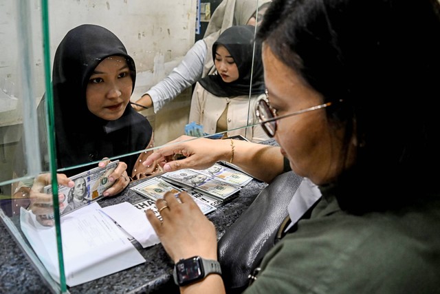 Petugas melayani penukaran uang dolar AS di salah satu gerai penukaran uang asing di Jakarta, Rabu (17/4/2024). Nilai tukar rupiah melemah terhadap dolar Amerika Serikat (AS) hingga menembus Rp16.250 ribu per dolar AS pada Rabu (17/4/2024). Foto: Sulthony Hasanuddin/Antara Foto