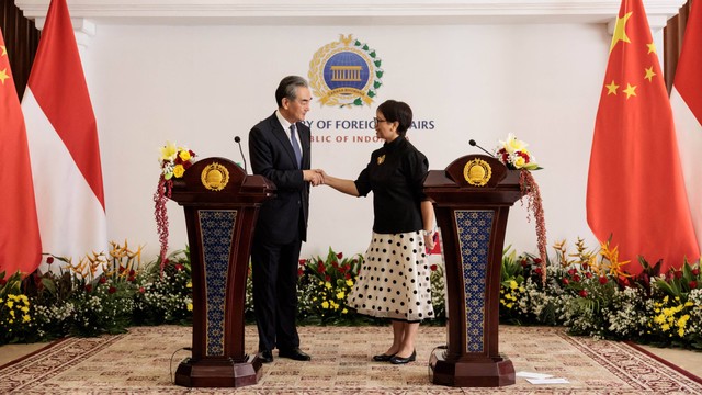 Menteri Luar Negeri Tiongkok Wang Yi (kiri) dan Menteri Luar Negeri Indonesia Retno Marsudi berjabat tangan saat mereka menyelesaikan konferensi pers usai pertemuan bilateral mereka di kantor Kementerian Luar Negeri di Jakarta pada 18 April 2024. Foto: Yasuyoshi CHIBA / AFP