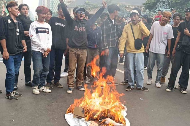 Massa aksi merobek dan membakar topeng berwajah tokoh politik dan hakim konstitusi dalam aksi demo di kawasan Patung Kuda, Jakarta Pusat, Kamis (18/4/2024) Foto: Fadlan Nuril Fahmi/kumparan
