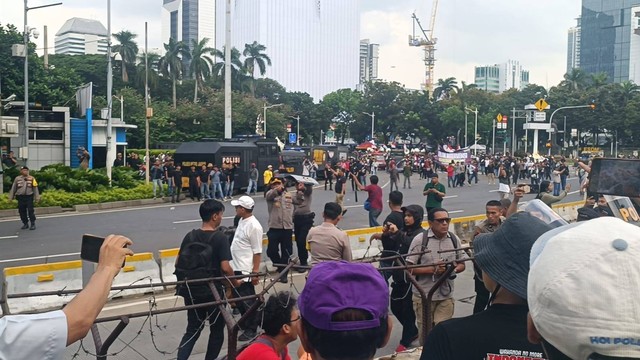 Massa aksi terlibat saling lempar botol air dan batu ke arah massa aksi pendukung Prabowo-Gibran, Patung Kuda, Jakarta Pusat, Jumat (19/4). Foto: Fadlan Nuril Fahmi/kumparan