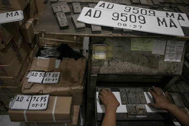 Petugas mencetak pelat nomor putih di kantor Samsat Solo, Jawa Tengah, Rabu (31/8/2022). Foto: Mohammad Ayudha/Antara Foto