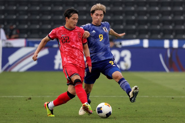 Timnas Korea Selatan U-23, Lee Tae-seok, duel dengan pemain Jepang, Shota Fujio, dalam matchday ketiga Piala Asia U-23 2024 di Jassim Bin Hamad Stadium, Al Rayyan, Qatar, pada Senin (22/4). Foto: KARIM JAAFAR/AFP