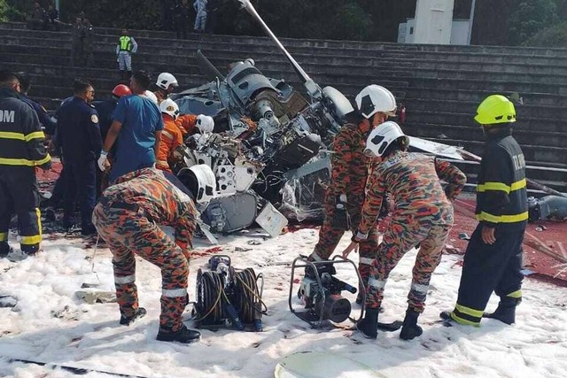 Personil darurat bekerja di lokasi kecelakaan helikopter di Lumut, Perak, Malaysia, Selasa (23/4/2024). Foto: FRDM/via AP PHOTO