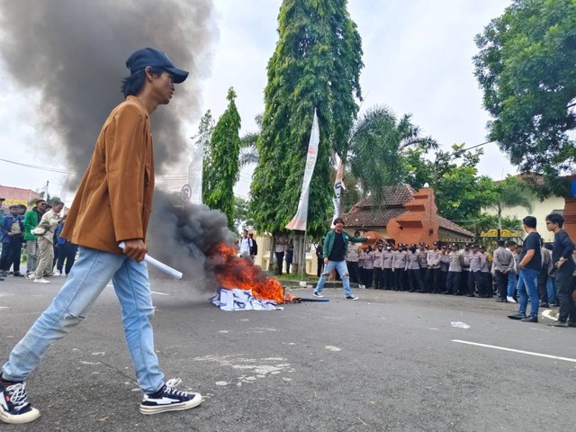 Aksi demonstrasi yang digelar oleh puluhan mahasiswa di depan Kantor DPRD Kabupaten Cirebon sambil membakar ban sebagai bentuk protes. Foto: Tarjoni/Ciremaitoday