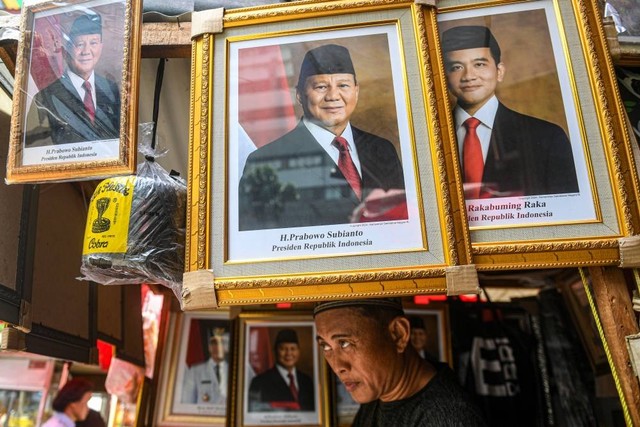 Pedagang menata foto pasangan Prabowo-Gibran sebagai Presiden dan Wakil Presiden 2024-2029 di kawasan Pasar Baru, Jakarta, Selasa (23/4/2024). Foto: Muhammad Adimaja/ANTARA FOTO