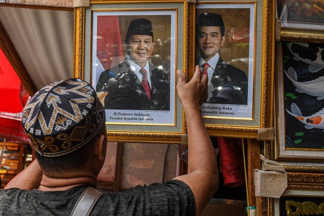 Pedagang menata foto pasangan Prabowo-Gibran sebagai Presiden dan Wakil Presiden 2024-2029 di kawasan Pasar Baru, Jakarta, Selasa (23/4/2024). Foto: Muhammad Adimaja/ANTARA FOTO