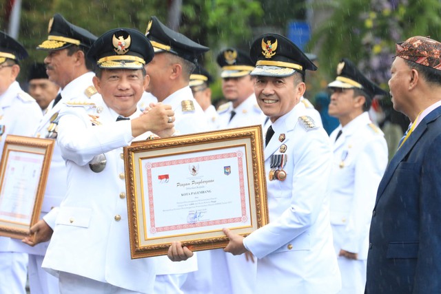Pj Wali Kota Palembang, Ratu Dewa, saat meraih penghargaan dari Mendagri, Tito Karnavian. (ist)