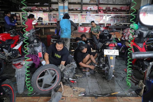 Montir memeriksa kondisi sepeda motor milik konsumen di bengkel Berkah Motor, Duren Tiga, Pancoran, Jakarta Selatan, Kamis (4/4/2024). Foto: Jamal Ramadhan/kumparan