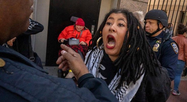Seorang perempuan demonstran pro-Palestina berteriak di hadapan polisi AS. 
