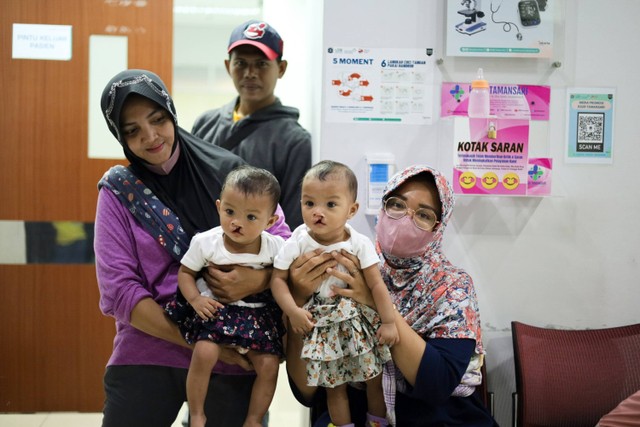 Antarkan Anak: Orang tua pasien mengangkat anak kembarnya yang akan melakukan operasi bibir sumbing di RSUD Tamansari Jakarta. Foto: Syawal Febrian Darisman/kumparan