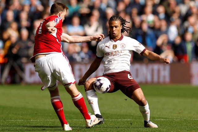 Pemain Nottingham Chris Wood berebut bola dengan pemanin Manchester City Nathan Ake pada pertandingan Liga Inggris di The City Ground, Nottingham, Inggris, Minggu (28/4/2024). Foto: Jason Cairnduff/REUTERS