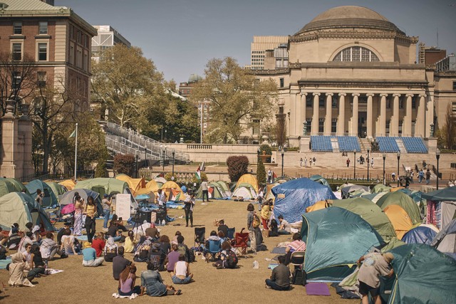 Orang-orang mendengarkan orasi di perkemahan pro-Palestina, menganjurkan pengungkapan keuangan dan divestasi semua perusahaan yang terkait dengan Israel dan menyerukan gencatan senjata permanen di Gaza, di dalam kampus Universitas Columbia. Foto: AP/Andres Kudacki