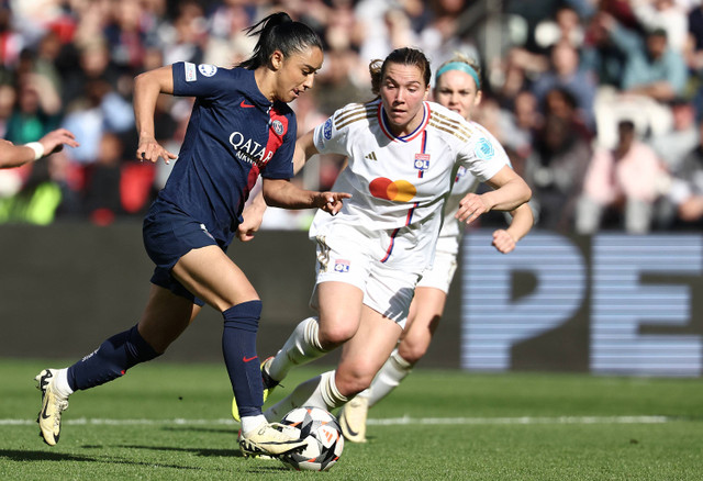 Bek Prancis Paris Saint Germain Sakina Karchaoui (Kiri) berebut bola dengan bek Lyon Kanada Vanessa Gilles selama pertandingan sepak bola leg kedua semifinal Liga Champions Wanita UEFA antara Paris Saint-Germain (PSG) dan Olympique Lyonnais (OL ). Foto: FRANCK FIFE / AFP