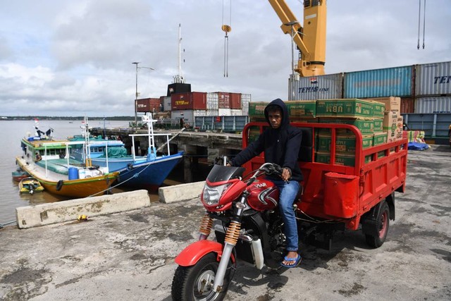 Warga mengangkut barang dari peti kemas menggunakan motor roda tiga di Pelabuhan Agats, Asmat, Papua, Rabu (30/6/2021). Foto: Puspa Perwitasari/Antara Foto