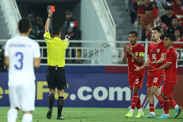 Wasit Shen Yinhao memberikan kartu merah kepada pemain Timnas U-23 Indonesia Rizky Ridho saat melawan Uzbekistan pada pertandingan semifinal Piala Asia U-23 di Stadion Abdullah Bin Khalifa, Doha, Qatar, Senin (29/4/2024). Foto: Karim Jaafar / AFP