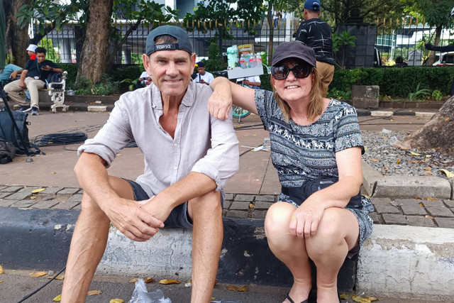 Kakak beradik Tony dan Sandra dari New Zealand kebingungan cari jalan ke Museum Gajah akibat jalan yang ditutup demo May Day di Patung Kuda, Jakpus, Rabu (1/5/2024) Foto: Thomas Bosco/kumparan