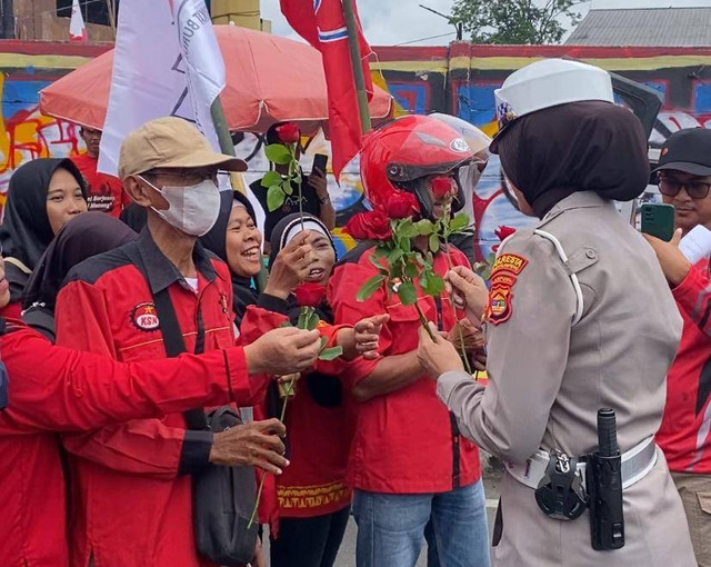 May Day, Polisi membagikan bunga sebagai simbol perdamaian dan perjuangan. | Foto: Sinta Yuliana/Lampung Geh