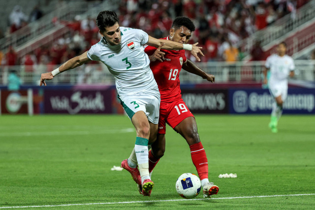 Pemain Timnas Indonesia U-23 Jeam Kelly Sroyer berebut bola dengan pemain Timnas Irak U-23 Ahmed Maknazi pada pertandingan perebutan tempat ketiga Piala Asia U-23 2024 di Stadion Abdullah bin Khalifa, Kamis (2/5/2024). Foto: KARIM JAAFAR/AFP