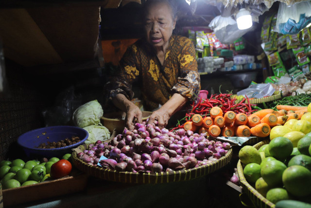 Pedagang menunjukkan bawang merah di Pasar Tebet Jakarta Selatan, Jumat (3/5/2024). Foto: Jamal Ramadhan/kumparan