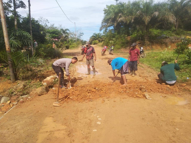 Bhabinkamtibmas Polsek Sekadau Hulu bersama warga Desa Perongkan memperbaiki jalan rusak. Foto: Dok. Polres Sekadau