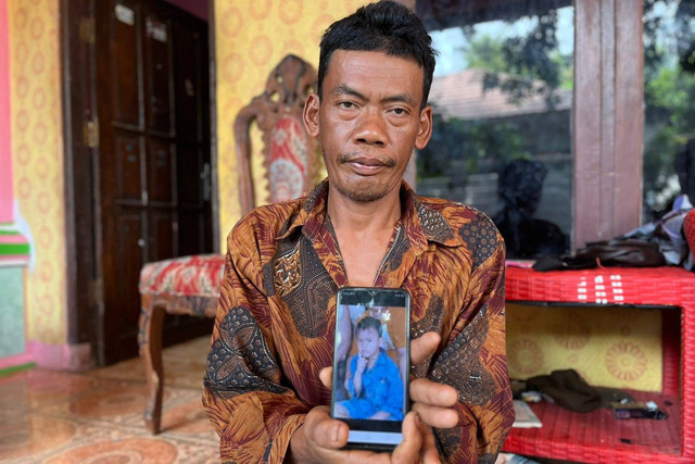Januri (45) ayah dari Farid (6) korban yang diduga diculik Kalong Wewe saat menunjukan foto anaknya. (5/5/2024).  Foto: kumparan