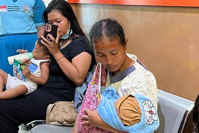 Fitri pemilik laundry saat menggendong bayi laki-laki yang ditemukan di dalam ember. Foto: Intan Alliva Khansa/kumparan