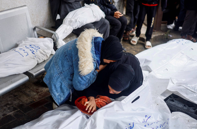 Pelayat memegang jenazah anak Palestina yang tewas dalam serangan Israel, di tengah konflik yang sedang berlangsung antara Israel dan kelompok Islam Palestina Hamas di rumah sakit Abu Yousef al-Najjar di Rafah, di Jalur Gaza Selatan (6/5/2024). Foto: Mohammed Salem / REUTERS