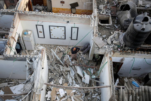 Warga Palestina memeriksa sebuah rumah yang rusak akibat serangan Israel, di tengah konflik yang sedang berlangsung antara Israel dan kelompok Islam Palestina Hamas, di Rafah, di selatan Jalur Gaza (7/5/2024). Foto: Hatem Khaled/REUTERS