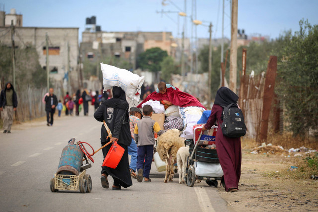 Warga Palestina dari Rafah dengan membawa barang-barang setelah perintah evakuasi oleh tentara Israel saat tiba di Khan Yunis, Senin (6/5/2024). Foto: AFP