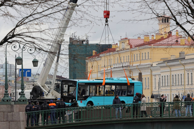 Spesialis mengangkat bus penumpang yang jatuh dari jembatan ke sungai di Saint Petersburg, Rusia, Jumat (10/5/2024). Foto: Anton Vaganov/Reuters
