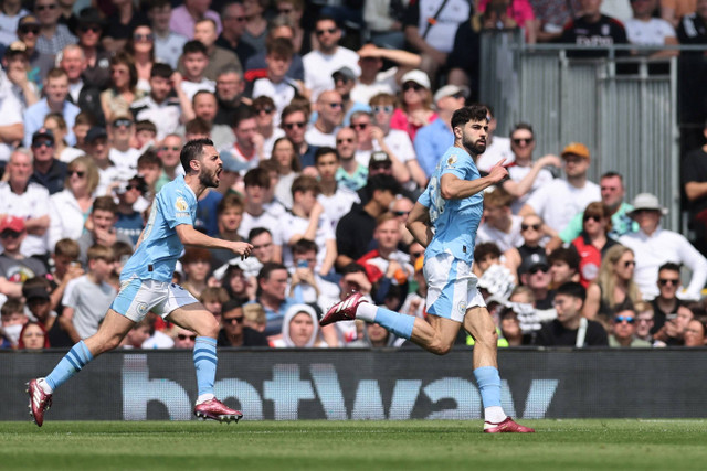 Pemain Manchester City Josko Gvardiol merayakan mencetak gol pertama mereka dengan Bernardo Silva di Craven Cottage, London, Inggris, Sabtu (11/5/2024). Foto: David Klein/Reuters