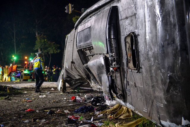 Petugas kepolisian berdiri di samping bangkai bus yang terlibat kecelakaan di Desa Palasari, Kecamatan Ciater, Kabupaten Subang, Jawa Barat, Sabtu (11/5/2024). Foto: Raisan Al Farisi/ANTARA FOTO