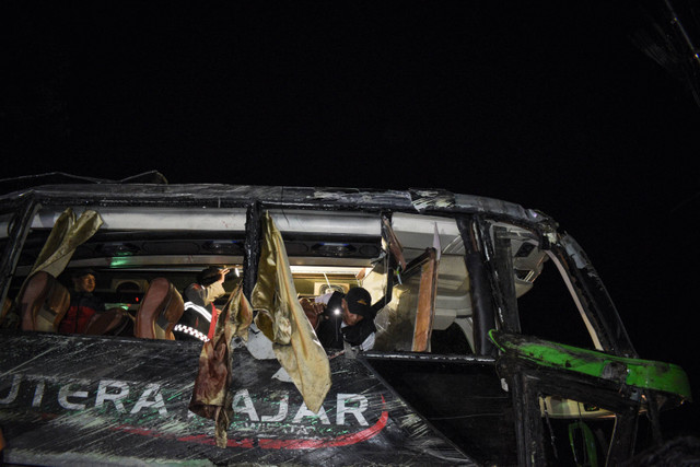 Petugas memeriksa bagian dalam bus pasca kecelakaan yang menewaskan 11 orang, menurut polisi setempat, di Subang, Jawa Barat (11/5/2024). Foto: Timur Matahari / AFP