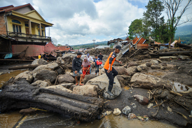 Petugas dibantu warga melakukan evakuasi warga usai banjir bandang di Nagari Bukik Batabuah, Agam, Sumatera Barat, Minggu (12/5/2024). Foto: Iggoy el Fitra/ ANTARA FOTO
