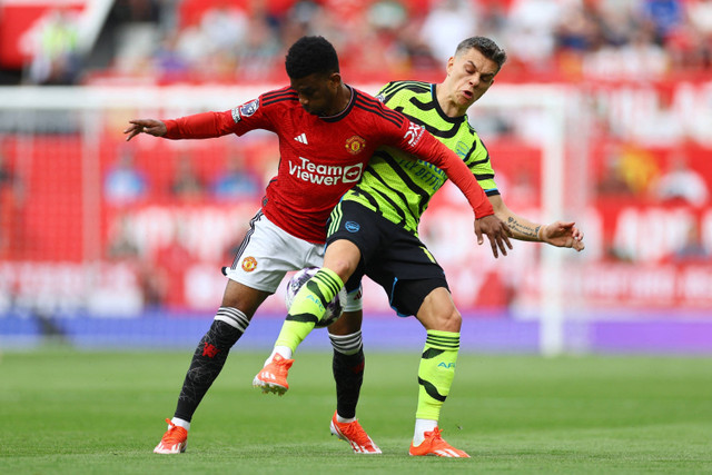 Pemain Manchester United Amad Diallo berebut bola dengan pemain Arsenal Leandro Trossard pada pertandingan lanjutan Liga Inggris di Old Trafford, Manchester, Inggris, Minggu (12/5/2024). Foto: Carl Recine/REUTERS