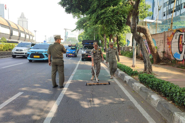 Petugas Satpol PP Sisir Jalan M.T. Haryono untuk deteksi paku, Senin (13/5/2024). Foto: Rachmadi Rasyad/kumparan