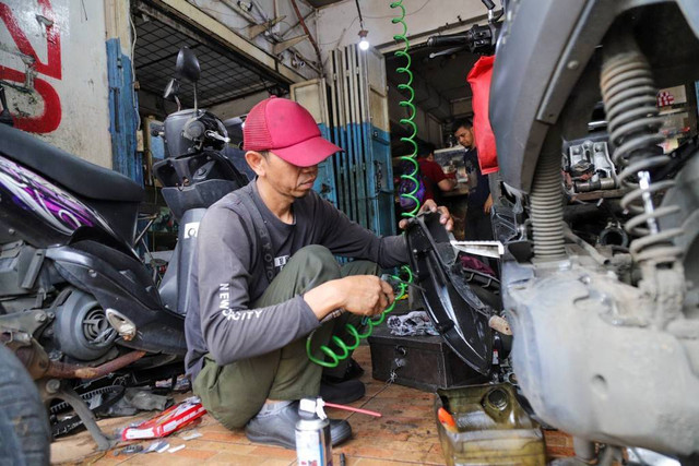 Montir memeriksa kondisi sepeda motor milik konsumen di bengkel Berkah Motor, Duren Tiga, Pancoran, Jakarta Selatan, Kamis (4/4/2024). Foto: Jamal Ramadhan/kumparan