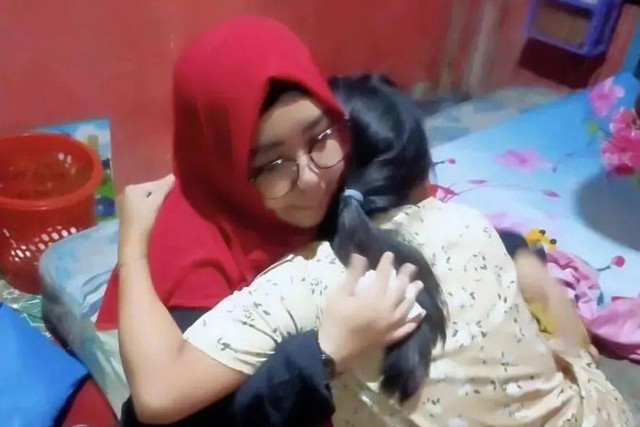 Tim Reaksi Cepat Perlindungan Anak dan Perempuan (TRC PPA) (kiri) memeluk wanita berinisial SL yang nyaris membunuh balitanya. Foto: Dok. Istimewa