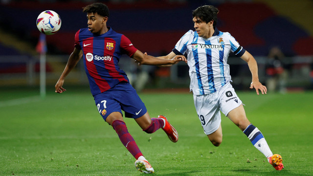 Lamine Yamal duel dengan Jon Aramburu saat laga Barcelona vs Real Sociedad dalam pekan ke-35 Liga Spanyol 2023/24 di Estadi Olimpic Lluis Companys, Selasa (14/5) dini hari WIB. Foto: REUTERS/Albert Gea