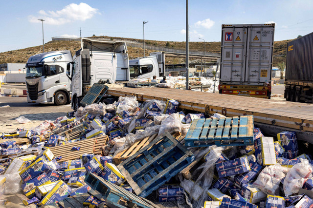 Truk trailer yang membawa pasokan kemanusian ke Gaza dirusak warga dan aktivis sayap kanan Israel di sisi Israel dari penyeberangan Tarqumiyah dengan Tepi Barat yang diduduki, Senin (13/5/2024). Foto: Oren Ziv / AFP