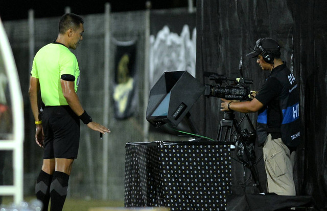 Wasit Heru Cahyono memeriksa kejadian melalui monitor VAR saat pertandingan semifinal leg pertama Championship Series Liga 1 antara Bali United melawan Persib Bandung di Training Center Bali United, Pantai Purnama, Gianyar, Bali, Selasa (14/5/2024). Foto: Fikri Yusuf/ANTARA FOTO