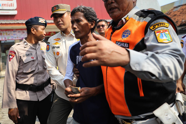 Petugas gabungan mengamankan Juru Parkir (Jukir) liar di kawasan Bungur Raya, Jakarta, Rabu (15/5/2024). Foto: Iqbal Firdaus/kumparan