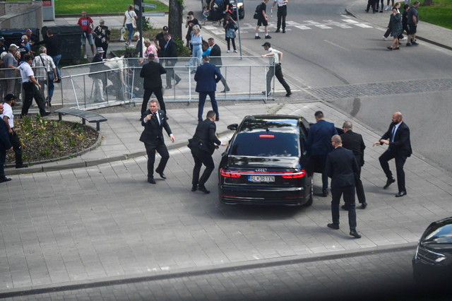 Petugas keamanan memindahkan PM Slovakia Robert Fico di dalam mobil setelah insiden penembakan, setelah pertemuan pemerintah Slovakia di Handlova, Slovakia, 15 Mei 2024. Foto: REUTERS/Radovan Stoklasa