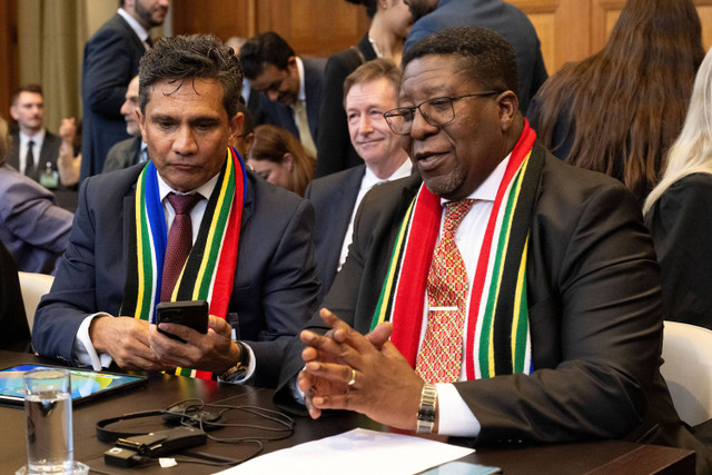 Penasihat hukum Afrika Selatan Cornelius Scholtz (kiri) dan Duta Besar Afrika Selatan untuk Belanda Vusimuzi Madonsela (kanan) terlihat setelah menyampaikan argumen mereka ke Mahkamah Internasional (ICJ) sebagai bagian dari kasus Afrika Selatan. Foto: Nick Gammon / AFP