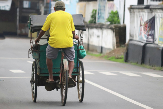 Pria tua berprofesi sebagai tukang becak. Foto oleh Mufid Majnun pada Unsplash.