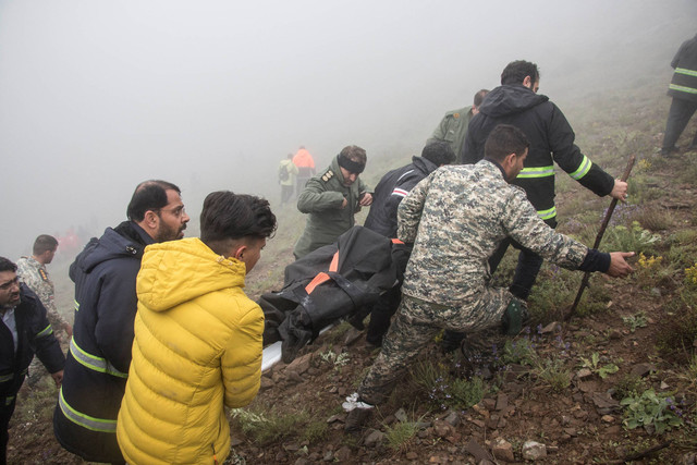 Tim penyelamat mengevakuasi korban jatuhnya helikopter yang ditumpangi Presiden Iran Ebrahim Raisi, di Varzaqan, Provinsi Azerbaijan Timur, Iran, Senin (20/5/2024). Foto: WANA/via REUTERS