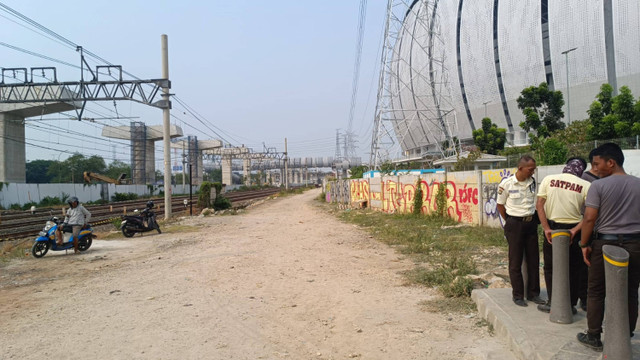 Jalan akses masuk Kampung Susun Bayam dijaga ketat petugas keamanan. Mereka mengaku diperintahkan JakPro untuk melarang siapapu, termasuk wartawan masuk, Selasa (21/5/2024). Foto: Thomas Bosco/kumparan