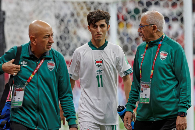 Penyerang Irak Hasan Abdulkarim (tengah) meninggalkan lapangan untuk perawatan selama pertandingan sepak bola grup A Piala Arab FIFA 2021 antara Qatar dan Irak di Stadion Al-Bayt di kota Al-Khor, Qatar pada 6 Desember 2021. Foto: JACK GUEZ/AFP