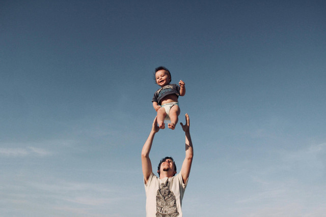 https://www.pexels.com/photo/photo-of-a-man-raising-baby-under-blue-sky-1166990/